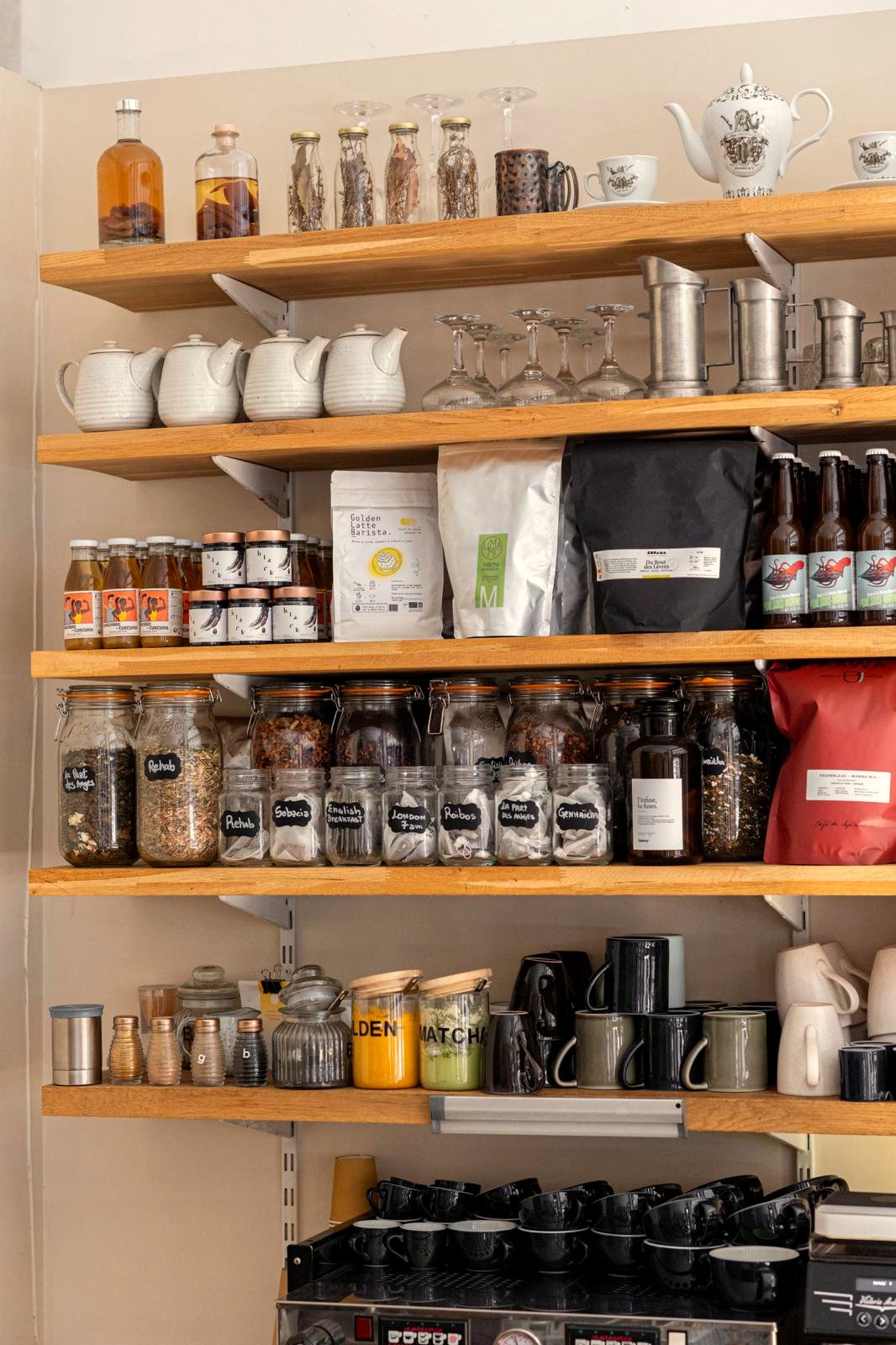 Les étagères du comptoir de Papilles : paquets de café, théières, bocaux et tasses